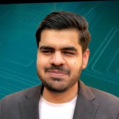 Abdullah, a young man with medium brown skin, neatly styled dark hair, and a short beard, smiles softly against a teal, tech-themed background. He is wearing a dark blazer over a light-colored shirt, giving him a professional, confident appearance.